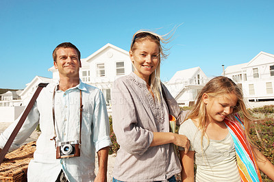 Buy stock photo Happy, parents and child for vacation at coast with picnic basket, sightseeing and weekend break. Support, portrait or people with girl outdoor for summer holiday, bonding or ready for family outing