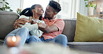 Couple, hug and happy on couch, home and laughing with partner in living room or bonding on weekend. Black people, embrace and affection for spouse on break, comfortable and together on sofa in house