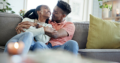 Buy stock photo Couple, hug and happy on couch, home and laughing with partner in living room or bonding on weekend. Black people, embrace and affection for spouse on break, comfortable and together on sofa in house