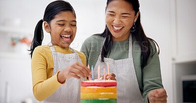 Buy stock photo Kid, baking and excited mother with birthday cake at home, celebration and laughing with candles. Parent, decor or girl with rainbow dessert for party preparation, funny or help in family kitchen