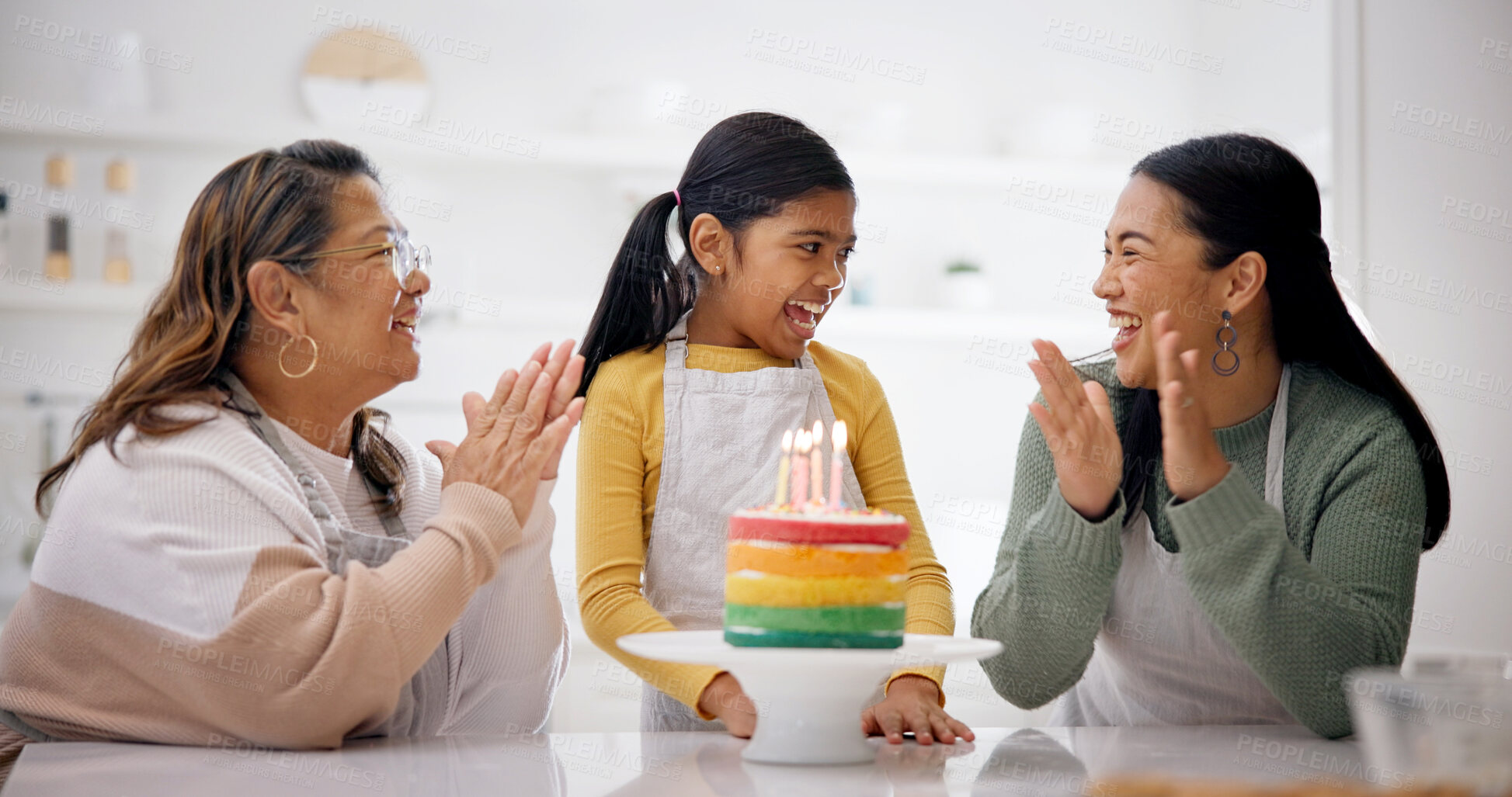 Buy stock photo Child, family and clapping with birthday cake in home after baking, laugh and generations sing. Mother, grandmother and girl with applause at party, rainbow dessert or excited to celebrate in kitchen