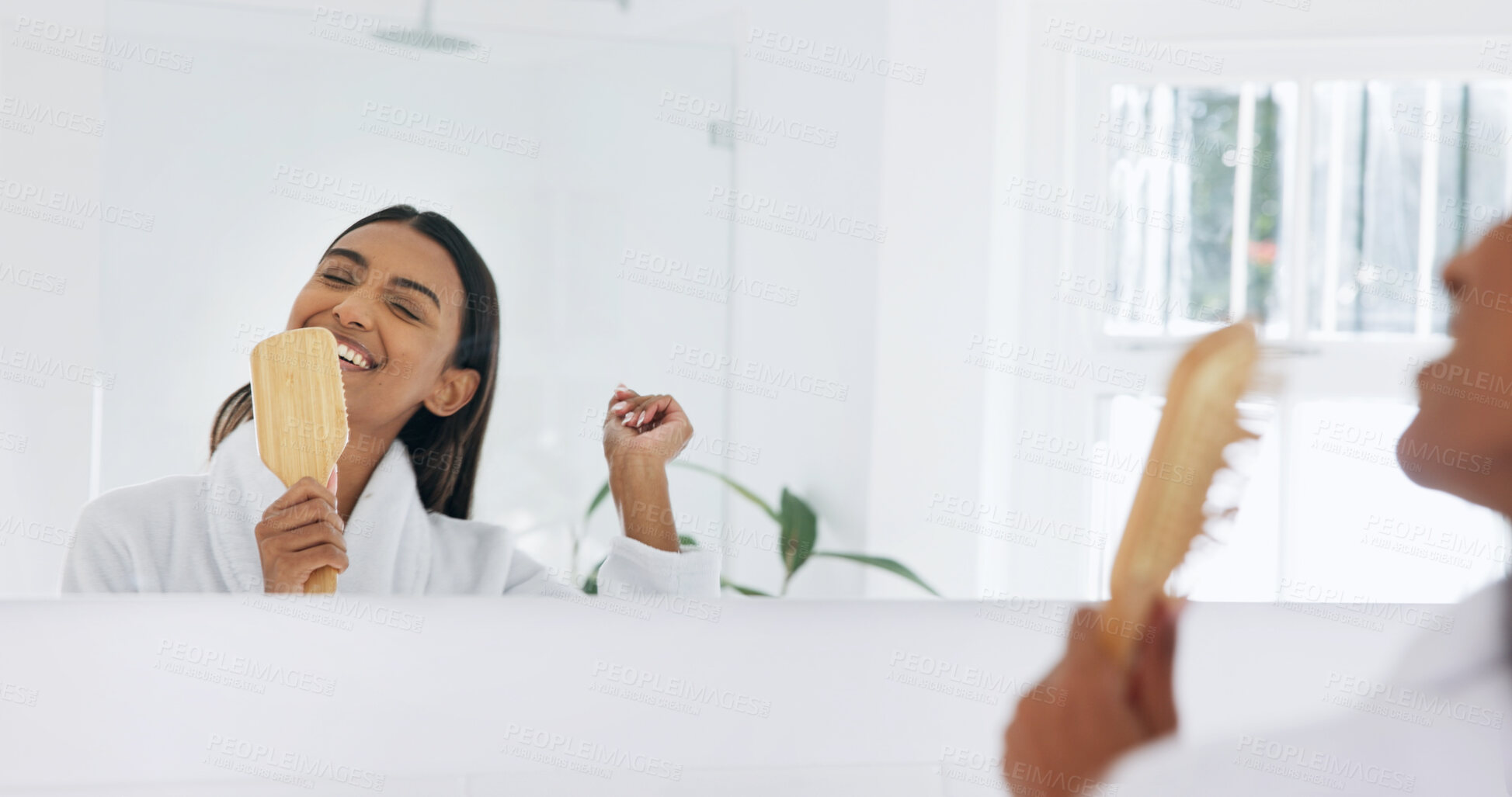 Buy stock photo Woman, happy and singing in mirror with hairbrush for morning routine, fun and hair care in bathroom. Bamboo brush, smile and reflection with person in home for beauty, karaoke and getting ready