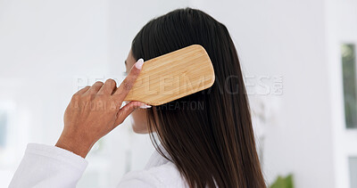 Buy stock photo Woman, brushing hair and haircare in home with back, morning routine and grooming in bathroom. Bamboo brush, female person and self care at house for beauty, texture and getting ready with tools
