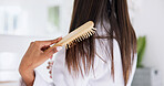 Hand, brushing hair and haircare in home with back, morning routine and grooming in bathroom. Bamboo brush, female person and self care in house for beauty, texture and getting ready with tools
