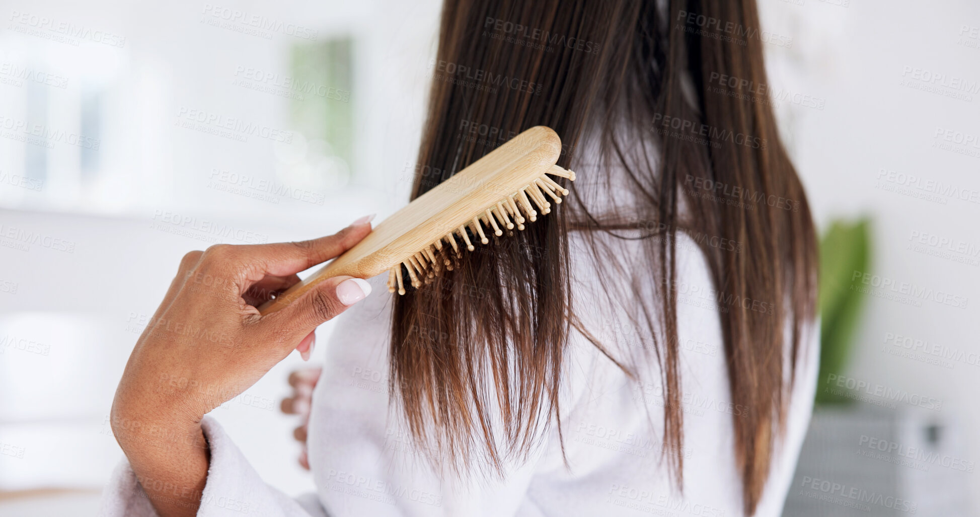 Buy stock photo Hand, brushing hair and haircare in home with back, morning routine and grooming in bathroom. Bamboo brush, female person and self care in house for beauty, texture and getting ready with tools