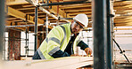 Man, carpenter and construction with measuring tape for woodwork, production or building design. Male person, contractor or industrial artisan with wood for architecture project or carpentry on site
