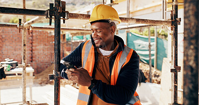 Buy stock photo Cellphone, black man and construction worker on site with texting for feedback on building infrastructure. Phone, communication and civil engineer with email for review on renovation or development.