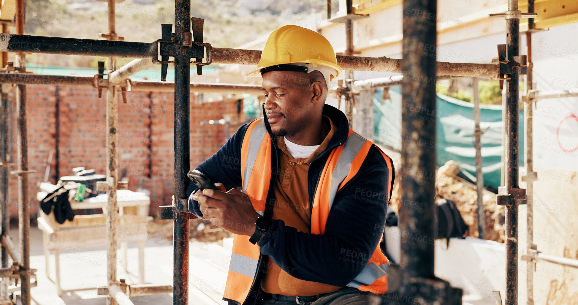 Buy stock photo Phone, black man and construction worker on site with texting for feedback on building infrastructure. Cellphone, communication and civil engineer with email for review on renovation or development.