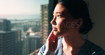 Buy stock photo Nurse, sad and woman with thinking at window for patient loss, process trauma and bad news. Healthcare professional, asian person or unhappy in clinic for medical crisis, hospital grief or reflection