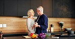 Dancing, smile and senior couple in kitchen for cooking with bonding, connection or marriage. Happy, ingredients and elderly man with woman for groove to music with love on home date together.
