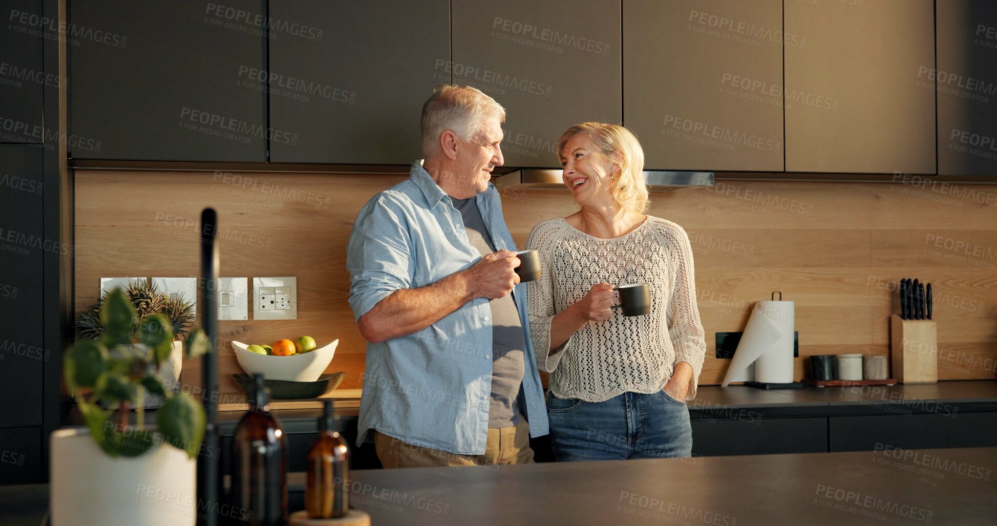 Buy stock photo Old couple, coffee and talking in kitchen with mug, beverage and retirement for morning routine. Home, reflection and elderly man and woman with discussion, herbal tea or communication with happiness