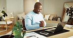 Excited, black man and fist pump at house with laptop, good news and success for loan approval. Male person, cheering and tech in home for celebration, lotto winner and cashback for financial freedom