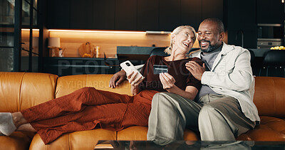 Buy stock photo Mature, couple and credit card in house with phone, plan holiday or payment for booking trip. Happy, interracial marriage and people in lounge with online banking, technology and travel expenses