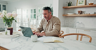 Buy stock photo Mature, finance and man with laptop for budget planning, report or home expenses in kitchen. Male person, accounting and typing on computer with book for financial review or tax assessment in house