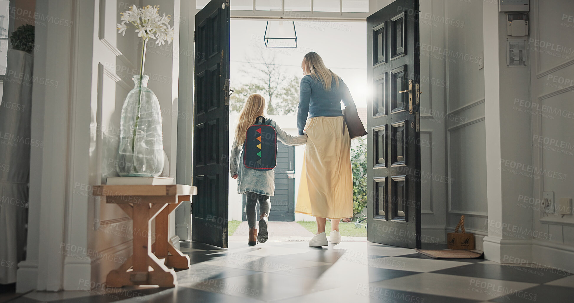 Buy stock photo Mom, leaving and girl in home with backpack, support and back to school for education. Woman, walking or front door with daughter for commute, morning routine and bonding together for learning