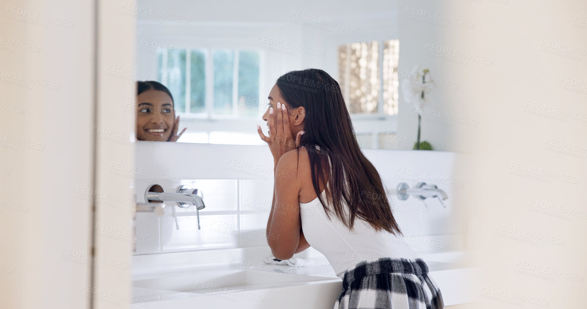 Buy stock photo Skincare, mirror and happy woman in bathroom, inspection and cosmetics for healthy skin and hydration. Reflection, check and person with glow, smile and self care with dermatology benefits in house