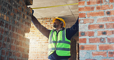 Buy stock photo Inspection, architect or man with tape measure at construction site, foundation distance or planning. Space, black person or accuracy check for building code compliance, structure integrity or tools
