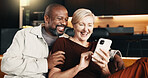 Interracial couple, phone and smile with hug for funny joke, mobile app and conversation in home. Mature people, communication and laugh for streaming entertainment on tech for humor on social media