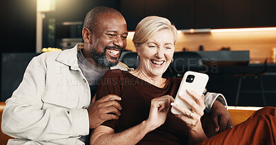 Buy stock photo Interracial couple, phone and smile with hug for funny joke, mobile app and conversation in home. Mature people, communication and laugh for streaming entertainment on tech for humor on social media