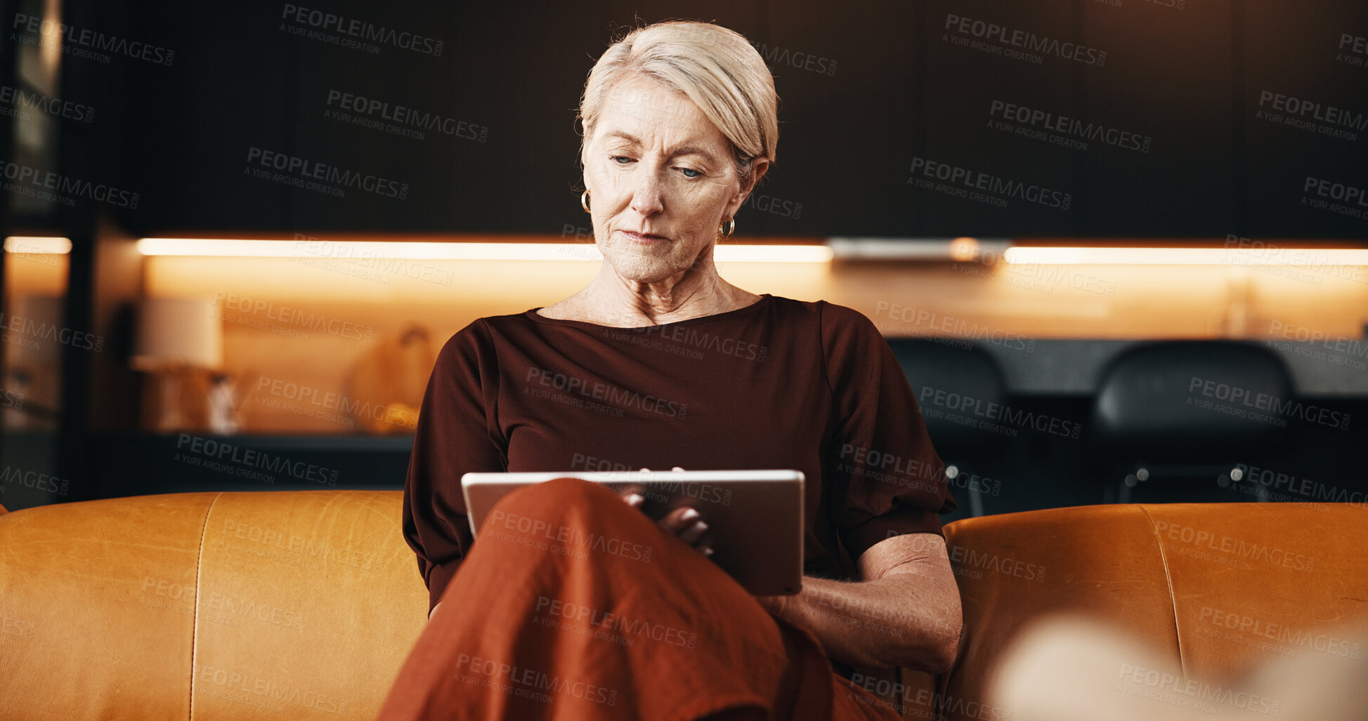 Buy stock photo Serious, reading and woman with tablet on couch, relax or app subscription for ebook on web in house. Chilling, reader and mature person with technology, home and novel download on sofa and online