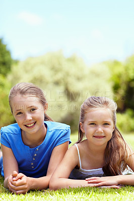 Buy stock photo Children, sisters and smile in portrait on grass for summer break, bonding together and support. Space, happy girls and relax at park for weekend outing, healthy relationship and sibling connection