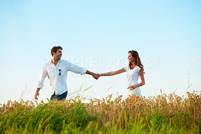 Buy stock photo Happy, couple and holding hands in wheat field for travel, bonding or romance in countryside. Space, man and woman in nature for weekend trip together with holiday, anniversary and playful vacation