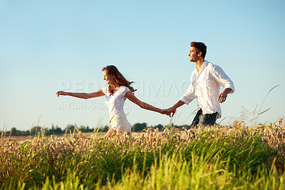 Buy stock photo Holding hands, running and love with couple in field for honeymoon getaway, support and trust. Freedom, connection and date with man and woman in countryside for fun, holiday and travel together