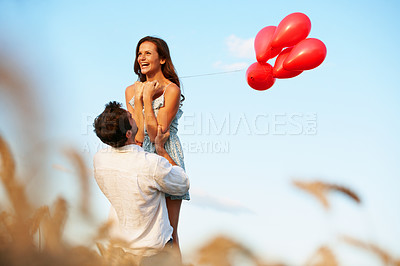 Buy stock photo Excited, couple and celebration outdoor with balloons, support and romantic gesture for anniversary. Space, married people and lift wife in countryside with relationship commitment, love and loyalty.