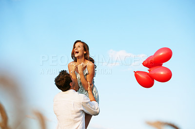 Buy stock photo Happy, couple and celebration outdoor with balloons, support or bonding together for anniversary. Space, excited married people and lift wife in countryside with romantic gesture, love or connection.