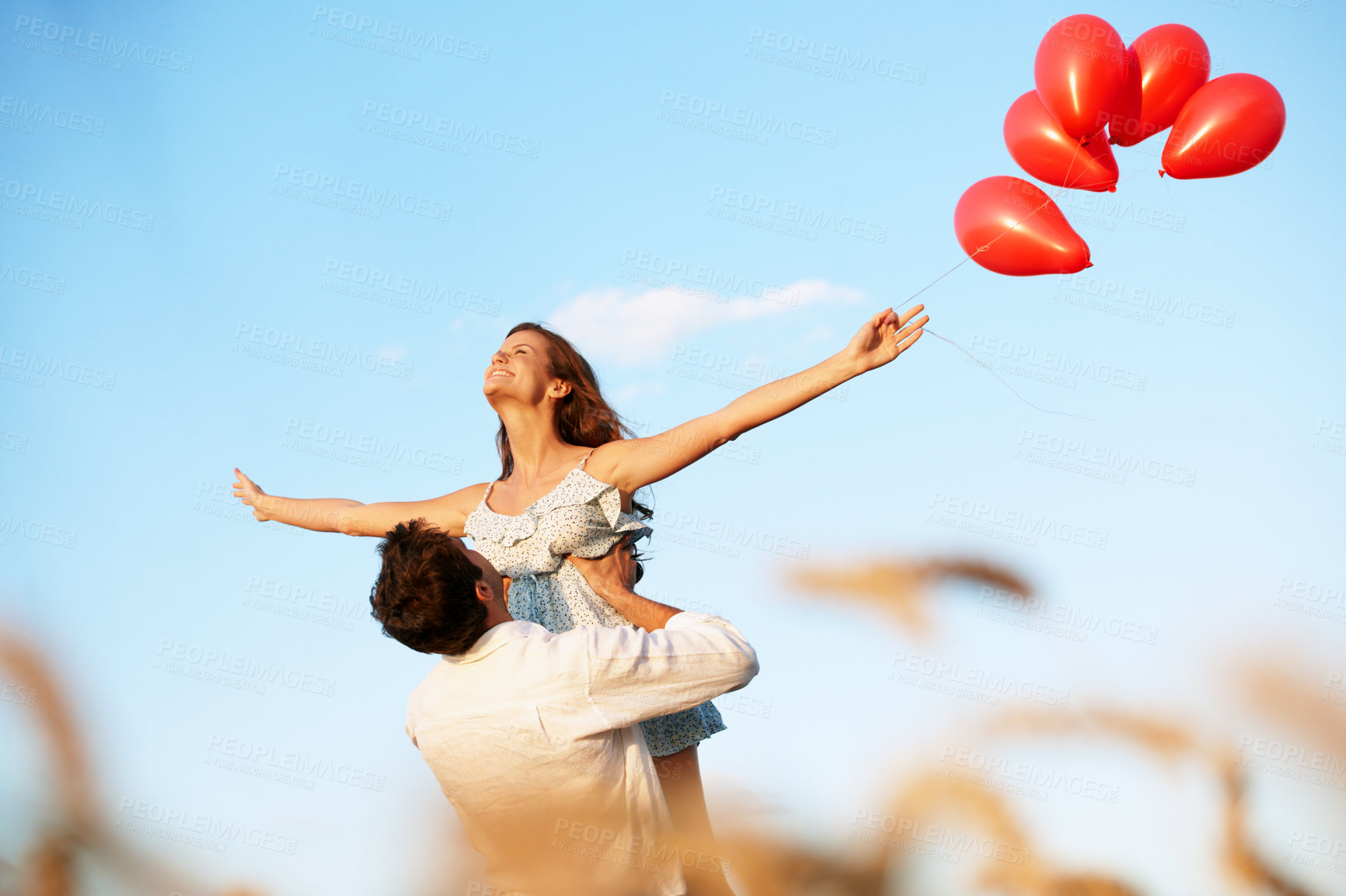 Buy stock photo Balloons, couple and lift in wheat field for vacation, bonding or romance in countryside. Freedom, man and woman in nature for weekend trip together with holiday, anniversary and playful celebration