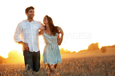 Buy stock photo Travel, sunset or couple with walk in field for anniversary getaway, holiday connection or trust. Sunshine, people or hug in countryside for romantic stroll, bonding or marriage conversation on space