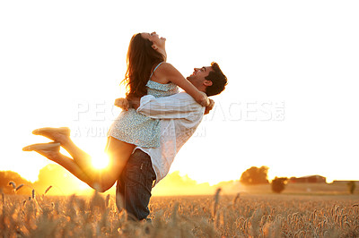 Buy stock photo Love, sunset or couple in field with carrying, fun moment and bonding on outdoor break. Flare, space or happy people in nature with hug, romantic connection or playful relationship on summer evening.