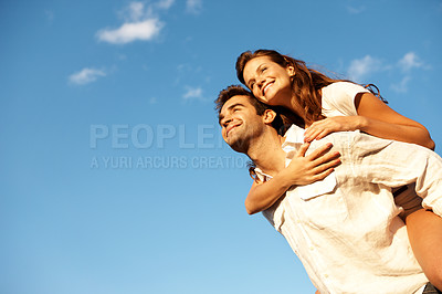 Buy stock photo Happy, couple or piggyback with blue sky for outdoor holiday or vacation together in nature. Low angle, man or carrying woman with smile, love or embrace for romance, date or weekend getaway on space