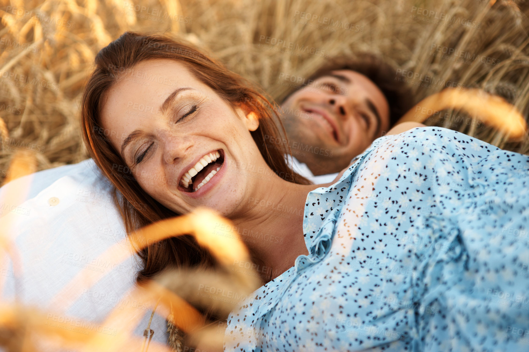 Buy stock photo Care, couple and relax at wheat field, laughing or bonding together for healthy relationship. Funny joke, woman and man rest at countryside farm with partner for love, smile or holiday outdoor