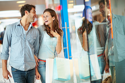 Buy stock photo Happy, couple and walk in mall with shopping bag, window reflection and bonding together on weekend. People, dating and customer discussion at store with retail sale, cashback promotion and discount.