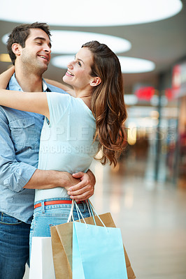 Buy stock photo Hug, mall and happy couple with shopping bag for love, purchase or bonding together in store. Man, woman or smile with gifts, embrace or care in commercial center for consumerism, date or spending