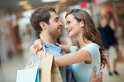 Buy stock photo Hug, happy and couple with shopping bags in store at mall for bonding, connection and love in marriage. Smile, gift and man embracing woman with present in retail boutique for purchase together.