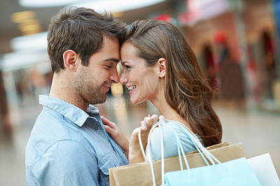 Buy stock photo Shopping bags, happy and couple with forehead touch in mall with bonding, love and connection. Smile, retail and man with woman for care with gift or present at boutique or store on weekend together.