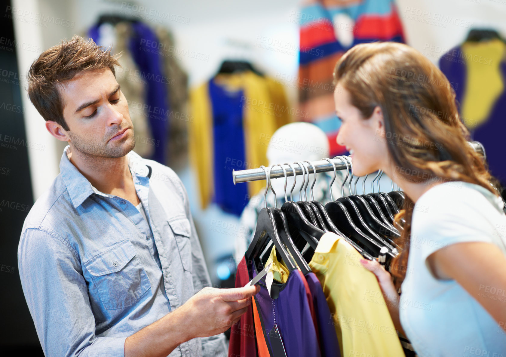 Buy stock photo Couple, shopping or checking for price tag in boutique for finance or affordable spending together. Woman, man and barcode with clothing rack in store for retail discount, deal or budget in mall