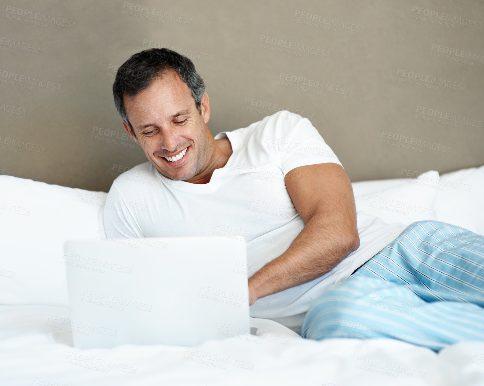 Buy stock photo Morning, man and relax with laptop on bed for series subscription, movie and peaceful holiday. Happy, mature person or tech in bedroom for streaming film, tv show or comfortable weekend break in home