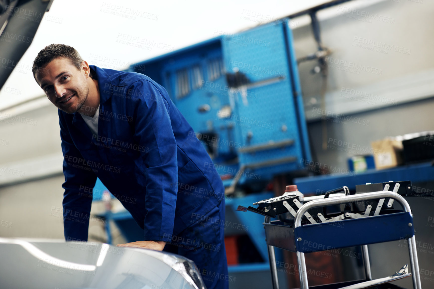 Buy stock photo Portrait, mechanic and happy man with car, fix and transportation maintenance at garage. Repair shop, auto technician and person by vehicle hood for service, motor inspection and engine diagnostic