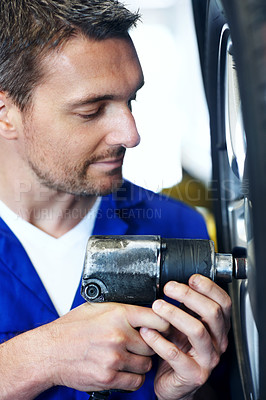 Buy stock photo Tire, mechanic and man with impact wrench, fixing and car maintenance with wheel change at garage. Power tools, person and equipment for vehicle service, replace bolt and repair with auto technician