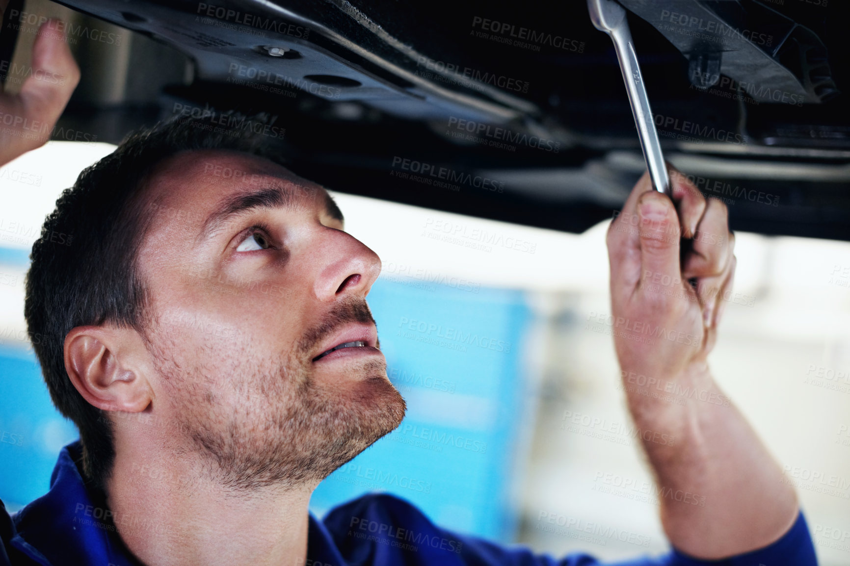 Buy stock photo Wrench, mechanic and man under car for maintenance, fix and suspension calibration at workshop. Tools, auto technician and person with vehicle for service, transmission inspection or repair at garage