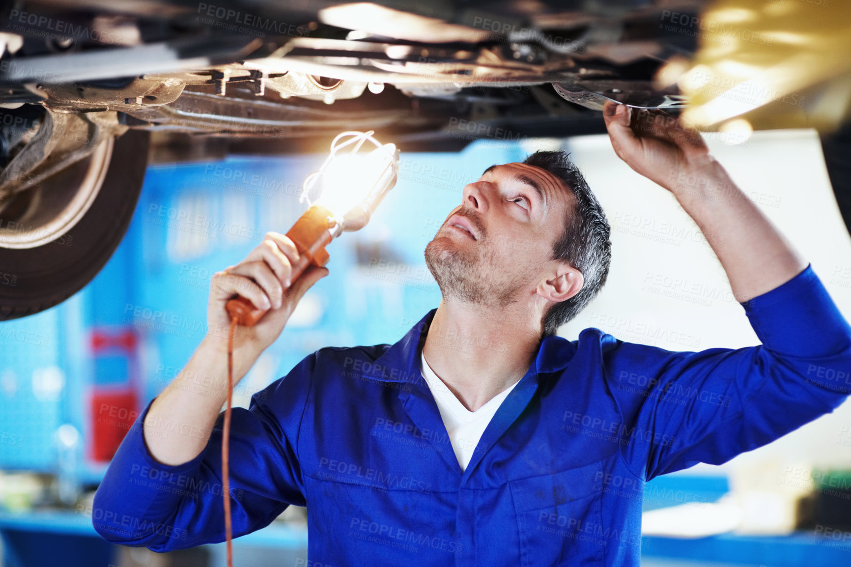 Buy stock photo Fix, light and maintenance with man in garage for vehicle inspection, repair or service. Car, lamp and undercarriage with mechanic in automobile workshop for check, compliance or engineering job