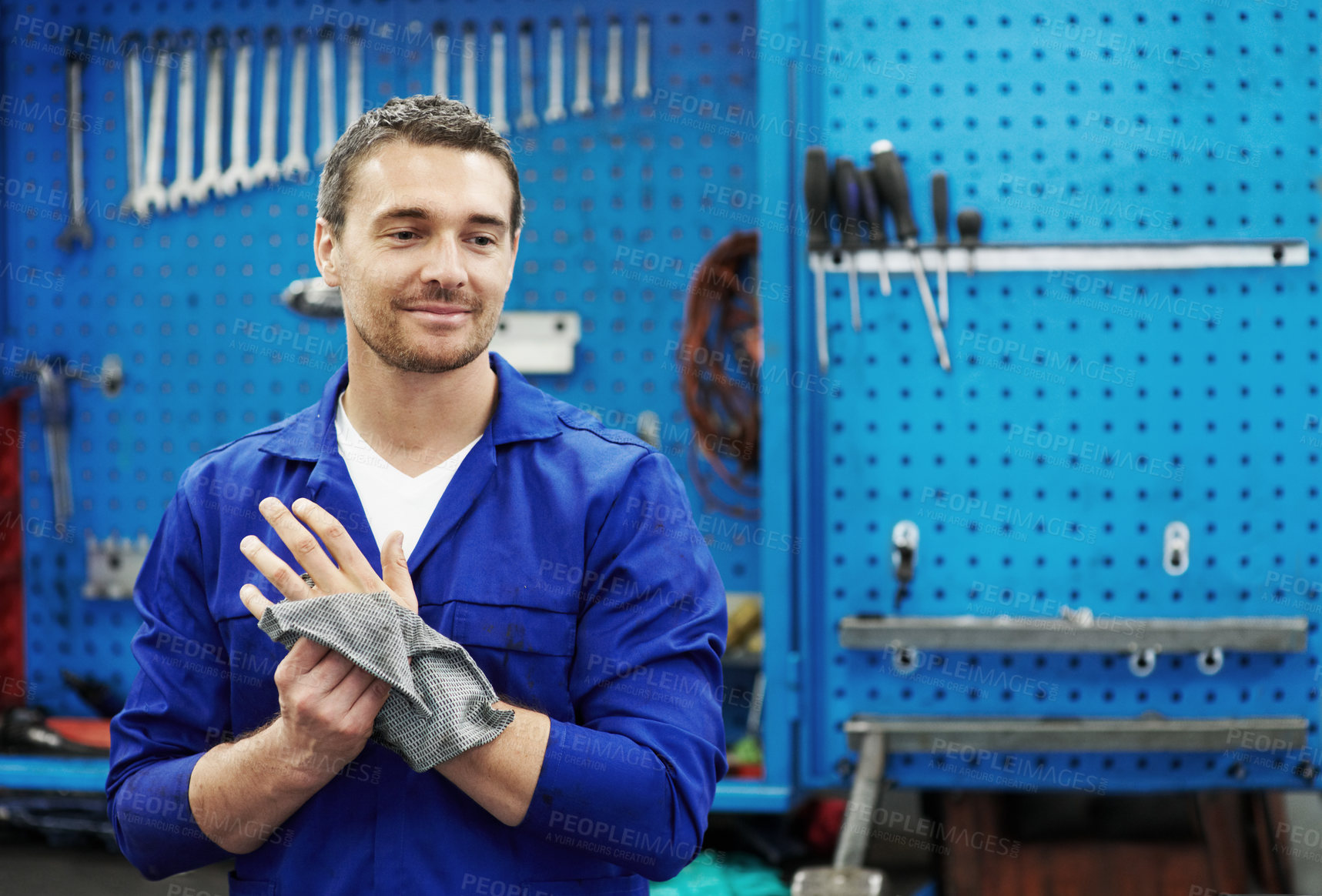 Buy stock photo Man, mechanic and cloth for hands at garage in portrait for hygiene, inspection or repair service. Person, technician or engineer with vehicle, confidence or rag for oil with career in auto workshop