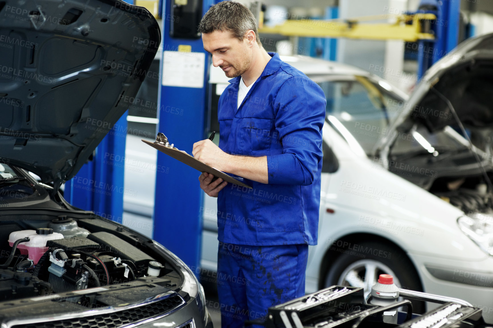 Buy stock photo Man, mechanic and writing on clipboard for car at workshop  for notes, inspection or repair services. Person, technician or engineer with vehicle, checklist and maintenance with career at auto garage