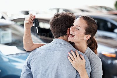 Buy stock photo Excited, couple and hug in car dealership with keys, transport investment or gratitude for purchase. Happy, woman and people embrace in showroom with new vehicle, relationship or thankful for partner