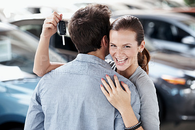 Buy stock photo Portrait, hug and happy couple in car dealership with keys, investment and gratitude for purchase. Excited, woman and people embrace in showroom with new vehicle, sale or thankful for partner
