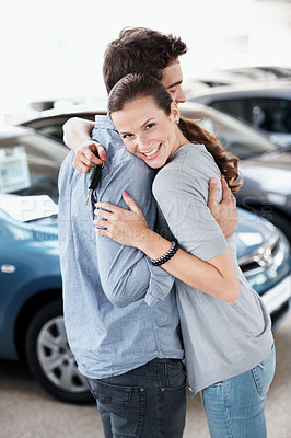 Buy stock photo Couple, hug and smile at car dealership with keys for purchase, buying and gift for anniversary. Man, woman and happy portrait for luxury present, gratitude or showroom for customer milestone