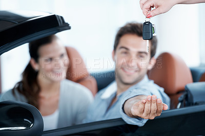 Buy stock photo Couple, hand or key at car dealership with salesperson for purchase, buy or test drive in automobile. Man, woman and giving keychain in convertible for vehicle ownership, smile or transportation